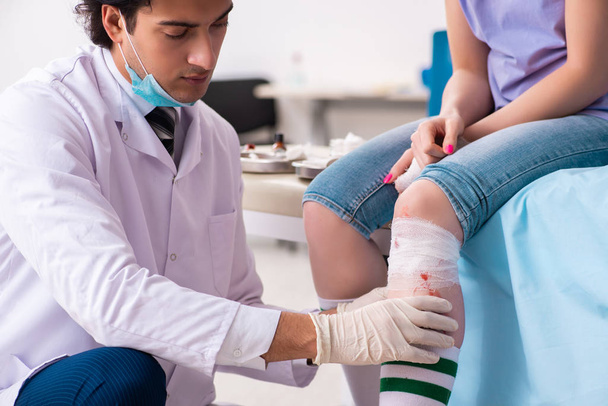 Раненая нога молодая женщина у врача-мужчины - Фото, изображение