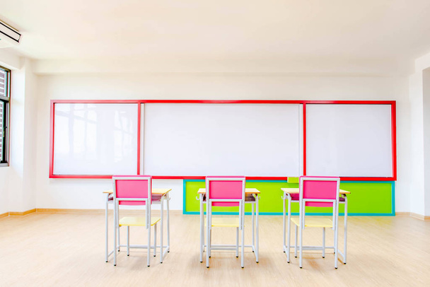 Bureaus, stoelen en whiteboard in de kleuterklas. - Foto, afbeelding