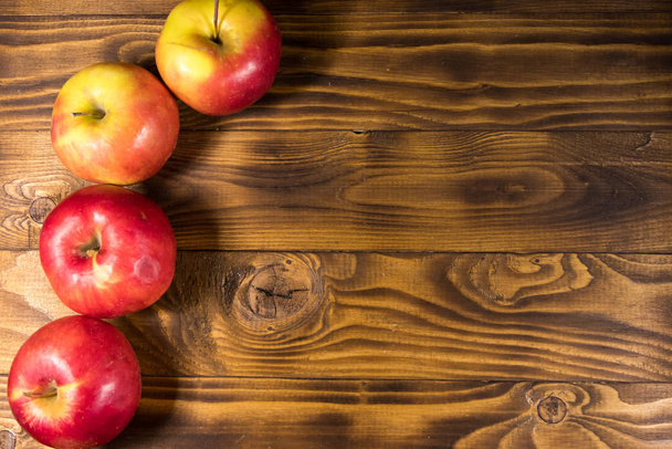 Červená jablka na dřevěném stole. Horní pohled, kopírovací prostor - Fotografie, Obrázek