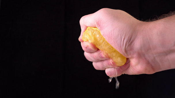 Close-up of a lemon. hand squeezes of lemon juice - Felvétel, videó