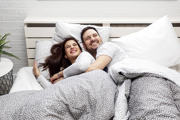 Jovem casal dormindo na cama no quarto
 - Foto, Imagem