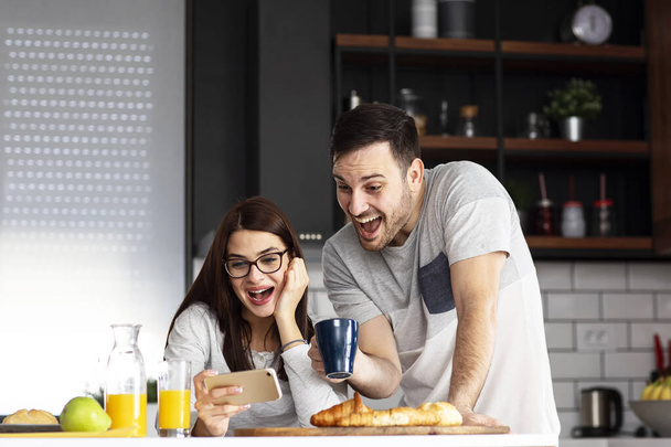Couple in the kitchen with breakfast in morning - Photo, Image