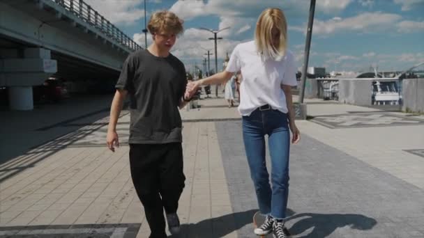 El tipo está enseñando a su novia a patinar. Fecha de los hipsters
. - Metraje, vídeo