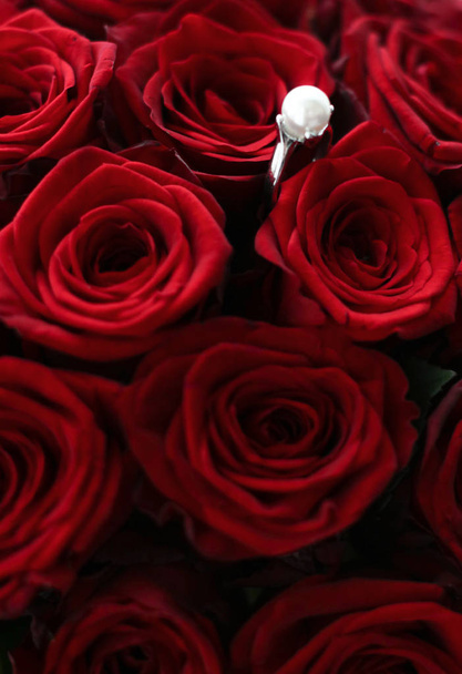 Krásný bílý zlatý perlový prsten a kytice červených růží, přepych - Fotografie, Obrázek