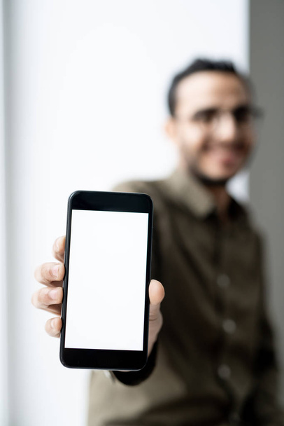 Smartphone s prázdným dotykovým displejem v ruce mladého současného podnikatele stojící před kamerou - Fotografie, Obrázek