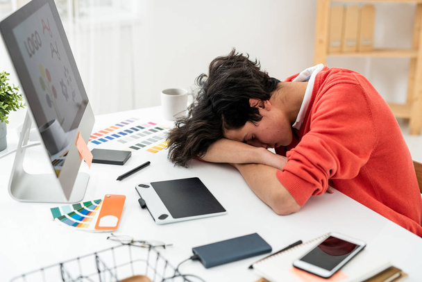 Vyčerpaný volný nocleh na stole počítačem mezi pracovní zásoby a pomůcky po práci - Fotografie, Obrázek