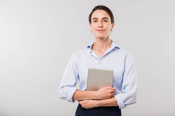 Young elegant businesswoman with touchpad standing in front of camera while posing in isolation - Foto, immagini