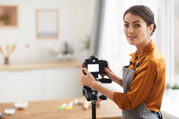 Περιμένετε μέχρι πορτρέτο της όμορφης γυναίκας ρύθμιση φωτογραφική μηχανή και χαμογελώντας, ενώ κινηματογράφηση μαγείρεμα φροντιστήριο στο στούντιο, αντιγραφή χώρο - Φωτογραφία, εικόνα