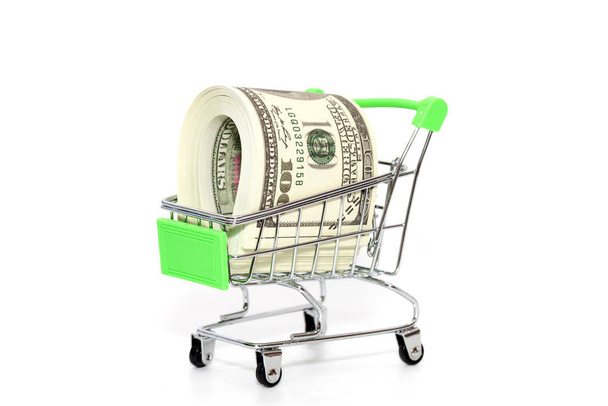 close up of mini shopping cart with banknote on white background - Foto, imagen