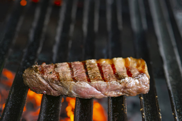 grilling steaks on flaming grill and shot with selective focus - Photo, Image