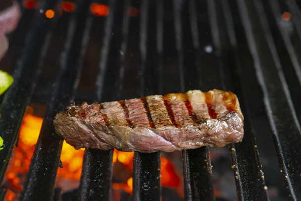 grilling steaks on flaming grill and shot with selective focus - Photo, Image