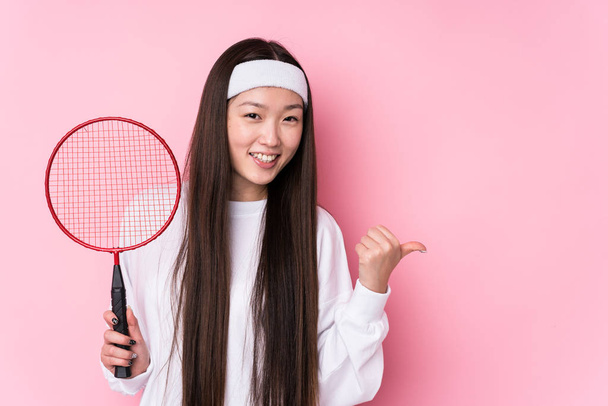 junge Chinesin spielt Badminton isoliert Punkte mit Daumenfinger weg, lacht und unbeschwert. - Foto, Bild