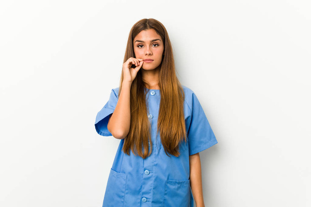 Young caucasian nurse woman with fingers on lips keeping a secret. - Foto, immagini