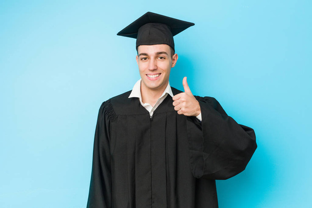 Jovem caucasiano graduado homem sorrindo e levantando o polegar
 - Foto, Imagem