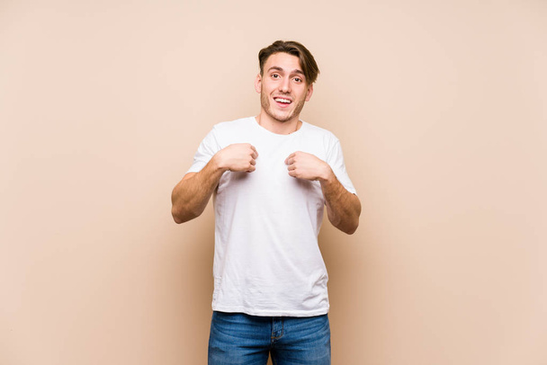 Young caucasian man posing isolated surprised pointing with finger, smiling broadly. - Photo, Image