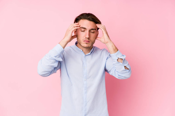 Young caucasian man posing in a pink background isolated touching temples and having headache. - Foto, imagen