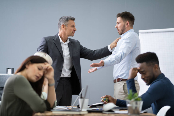 Group Of Businesspeople Looking At Businessman Blaming His Colleague In Meeting - Fotó, kép