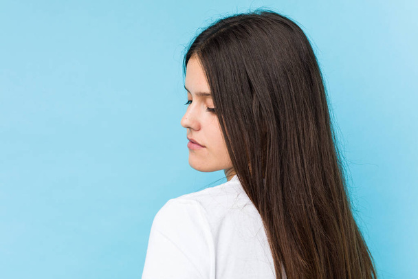 Fiatal kaukázusi lány arc closeup elszigetelt egy kék háttér - Fotó, kép