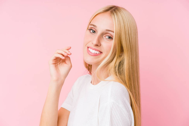 Nuori blondi nainen kasvot lähikuva eristetty vaaleanpunainen tausta
 - Valokuva, kuva