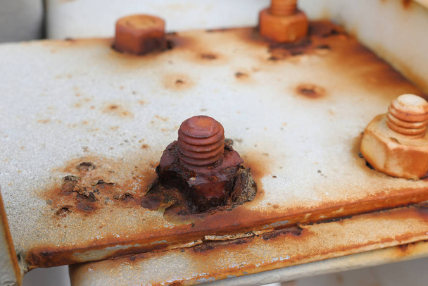 a corroded nut and bolt on a rusty metal plate with blurred background - Photo, Image