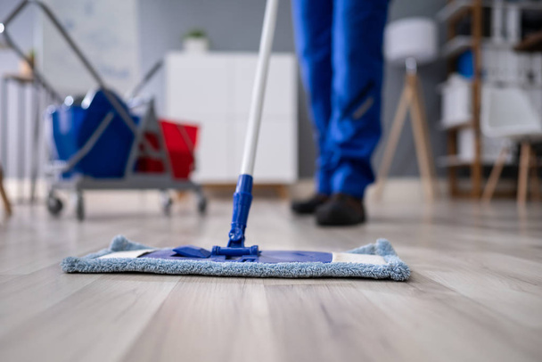 Happy Young Man Cleaning The Floor With Mop In Modern Office - Foto, afbeelding