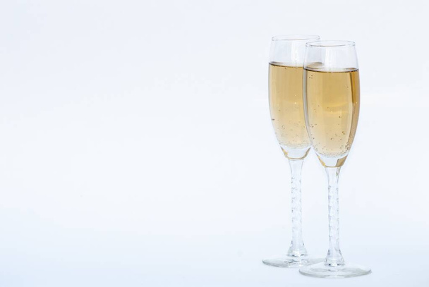 Two glasses of champagne on a white surface with a white background - Foto, afbeelding