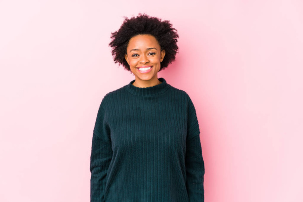 Donna afroamericana di mezza età su uno sfondo rosa isolato felice, sorridente e allegro
. - Foto, immagini