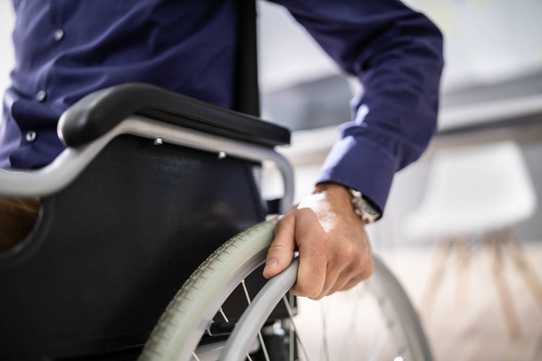 Close-up Of Businessman Sitting On Wheelchair In Office - Photo, image