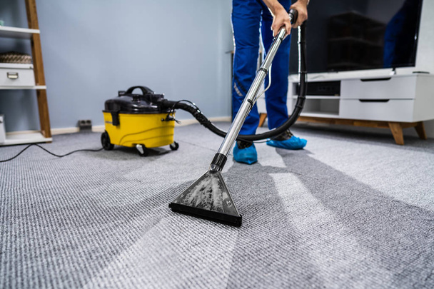 Photo Of Janitor Cleaning Carpet With Vacuum Cleaner - Foto, Imagen