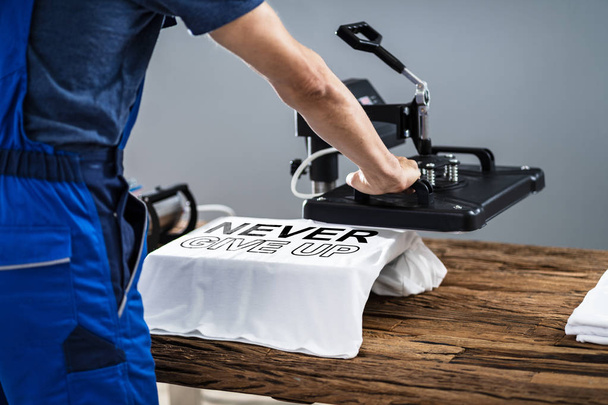 Man Printing On T Shirt In Workshop - Foto, Imagem