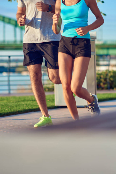 Moderne vrouw en man joggen / sporten in de stedelijke omgeving  - Foto, afbeelding
