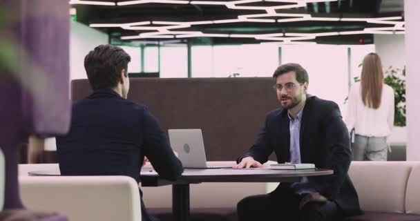 Two happy business partners wear suits negotiate handshake in office - Imágenes, Vídeo