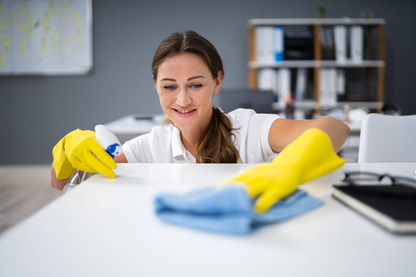 Young Worker Cleaning Desk With Rag In Office - Foto, Imagem