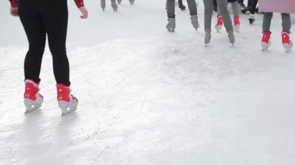 Туристы катаются крупным планом на большом катке. Ноги после катания на коньках по замерзшему озеру
. - Кадры, видео