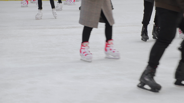 Τουρίστες κάνουν πατινάζ σε ένα μεγάλο παγοδρόμιο. Πόδια μετά το πατινάζ που πατινάζ σε μια παγωμένη λίμνη. - Πλάνα, βίντεο