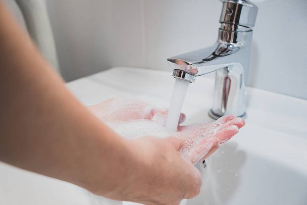 Washing hands with water in a sink. Cleaning hands, personal hygiene concept - Zdjęcie, obraz