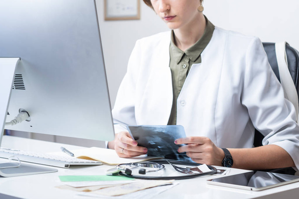 Médecine au cabinet médical moderne. Femme examinant les rayons X au travail devant un ordinateur de bureau
 - Photo, image