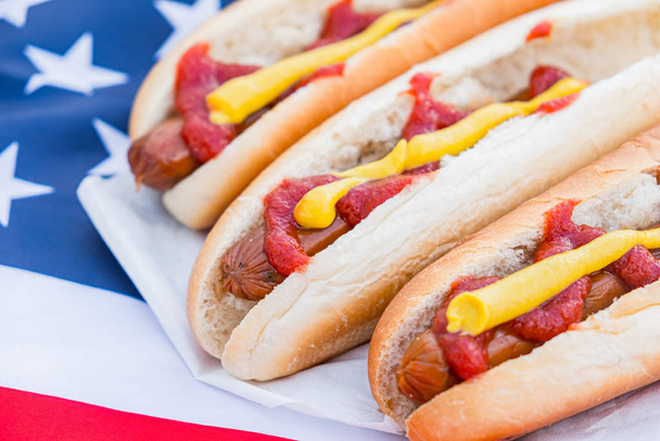 Typical american fastfood: hot dogs and american flag. Close-up view of stereotypical US food - Foto, imagen