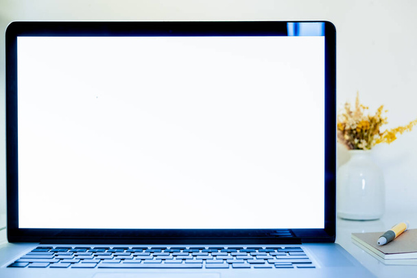 Egy laptop fehér képernyője, közeli másolás. Hordozható számítógép monitor egy modern íróasztalon, tartalék másolási hely szöveg vagy képek beillesztéséhez - Fotó, kép