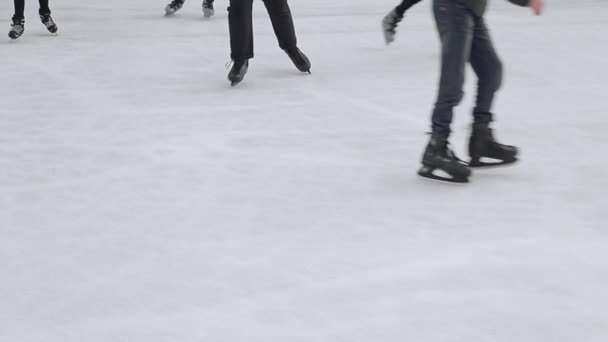 Los turistas patinan de cerca en una gran pista de patinaje. Pies después de patinar que patinan en un lago congelado
. - Imágenes, Vídeo
