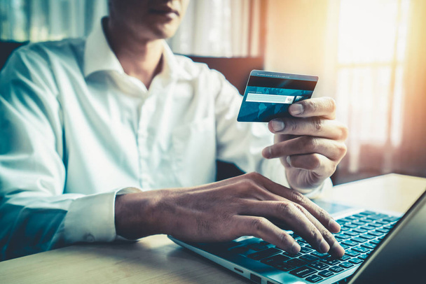 Hombre joven utilizar la tarjeta de crédito para el pago de compras en línea en la aplicación de ordenador portátil o sitio web. Concepto de comercio electrónico y compras en línea. - Foto, Imagen