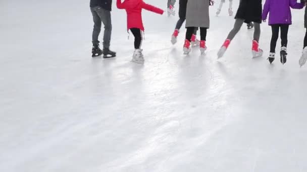 Touristen skaten aus nächster Nähe auf einer großen Eisbahn. Füße nach dem Schlittschuhlaufen auf einem zugefrorenen See. - Filmmaterial, Video