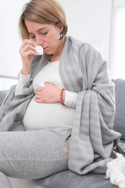 妊娠中の女性は風邪、インフルエンザ、ウイルスをキャッチし、 c上の自宅に座って - 写真・画像