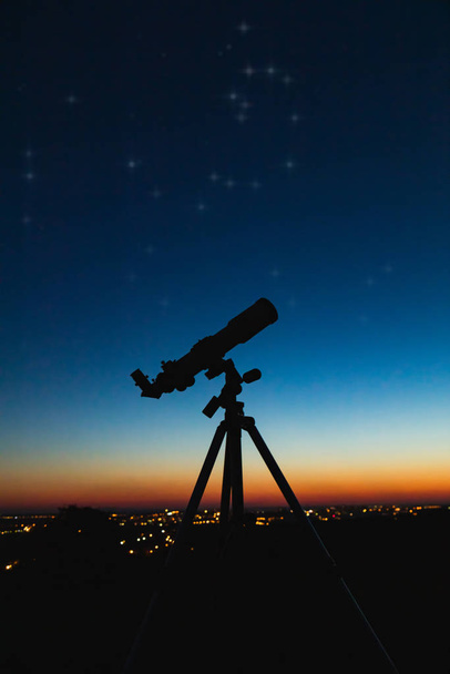 Силуэт телескопа и ночное небо с городским освещением в задней части
 - Фото, изображение