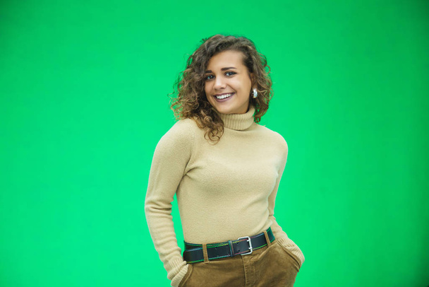 Glowing girl posing on green background, looking positive, smiling. - Fotografie, Obrázek