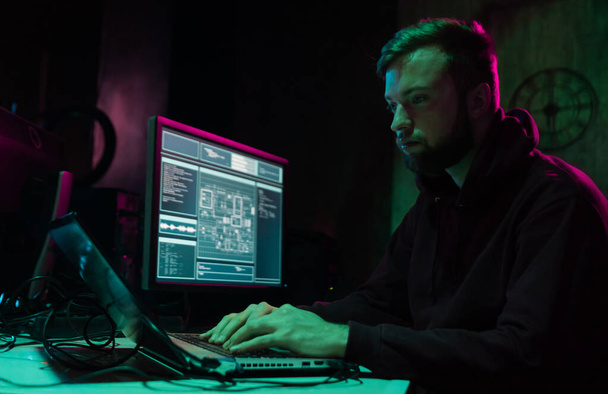 Wanted hackers coding virus ransomware using laptops and computers in the basement. Cyber attack, system breaking and malware concept. - Фото, зображення