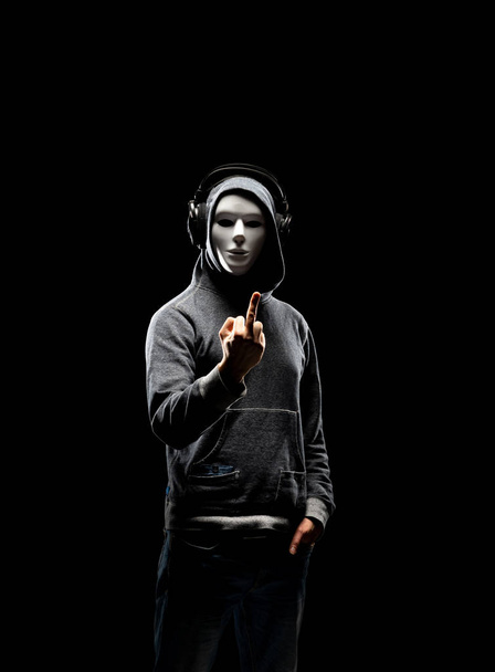 白いマスクやパーカーのコンピュータ ハッカーの肖像画。隠された暗い顔。データ泥棒、インターネット詐欺、ダークネットとサイバー セキュリティの概念. - 写真・画像