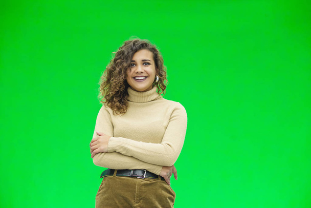 Friendly-looking girl with lovely sincere smile, looking thankful and grateful, standing against green background. - Foto, immagini