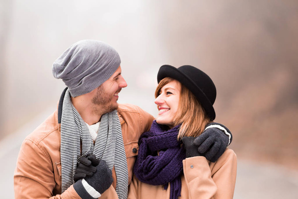 Пара, наслаждающаяся отдыхом на открытом воздухе в холодное время осени и зимы
. - Фото, изображение