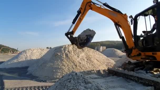 Bagger nivellieren das Gelände mit Sand und bewegen Sand von den Erdhügeln - Filmmaterial, Video